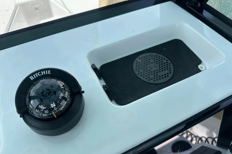 Slide: The Image of Compass and wireless charging pad on 2026 Sportsman Open 232 Center Console boat. - 46