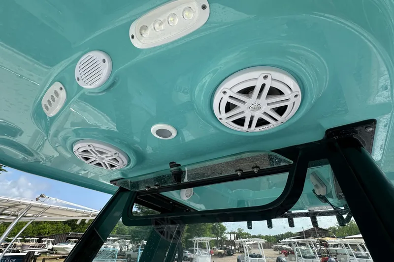 Slide: The Image of 2026 Sportsman Open 232 Center Console boat speakers and lights on teal interior ceiling. - 47