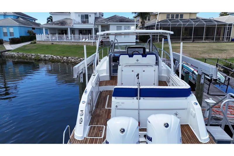 Slide: The Image of 2019 Jeanneau Leader 10.5 boat docked by waterfront homes. - 10
