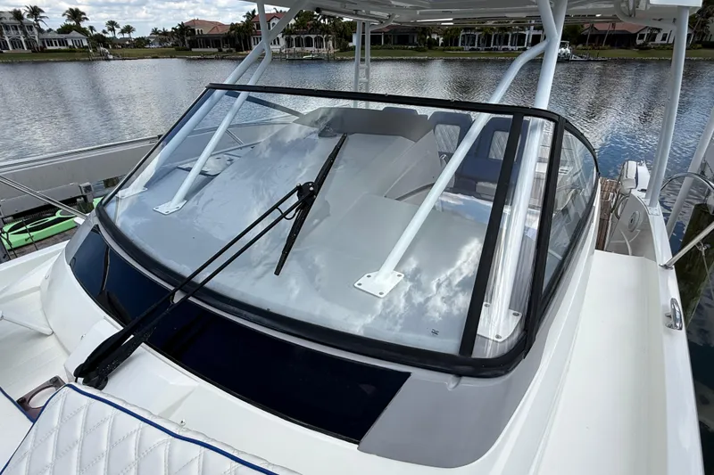 Slide: The Image of 2019 Jeanneau Leader 10.5 boat with windshield, docked by a scenic waterfront. - 100
