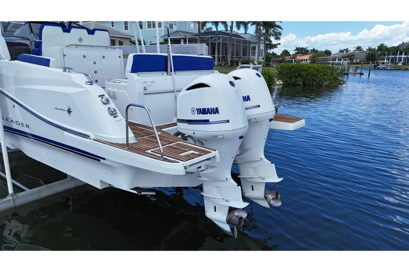 Slide: The Image of 2019 Jeanneau Leader 10.5 boat with twin Yamaha outboard engines docked by waterfront homes. - 11