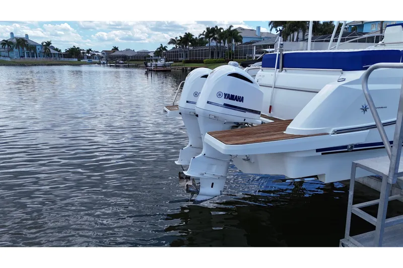 Slide: The Image of 2019 Jeanneau Leader 10.5 with Yamaha outboard motors docked by waterfront homes. - 12