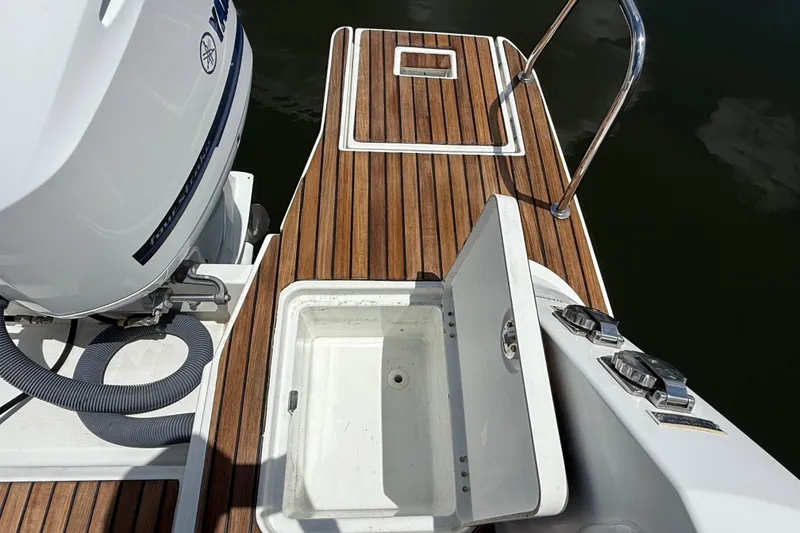 Slide: The Image of 2019 Jeanneau Leader 10.5 boat deck with open storage compartment and Yamaha outboard motor. - 20
