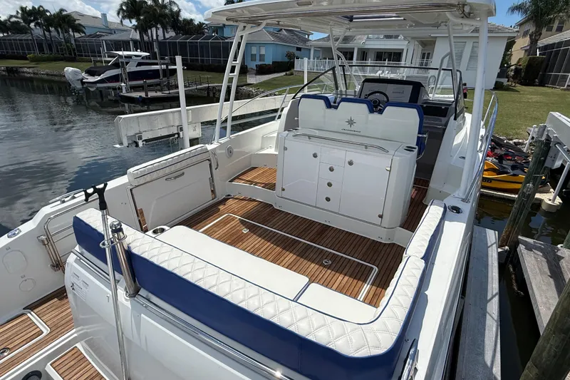 Slide: The Image of 2019 Jeanneau Leader 10.5 boat with spacious deck and elegant seating in marina. - 23
