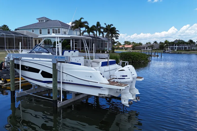 Slide: The Image of 2019 Jeanneau Leader 10.5 boat docked by waterfront homes, featuring Yamaha engines. - 3