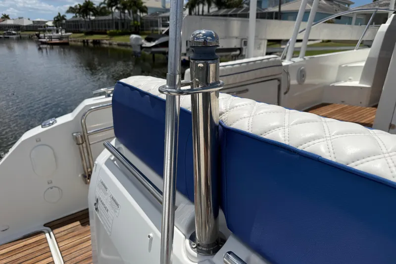 Slide: The Image of 2019 Jeanneau Leader 10.5 boat interior with blue and white seating, dockside view. - 30