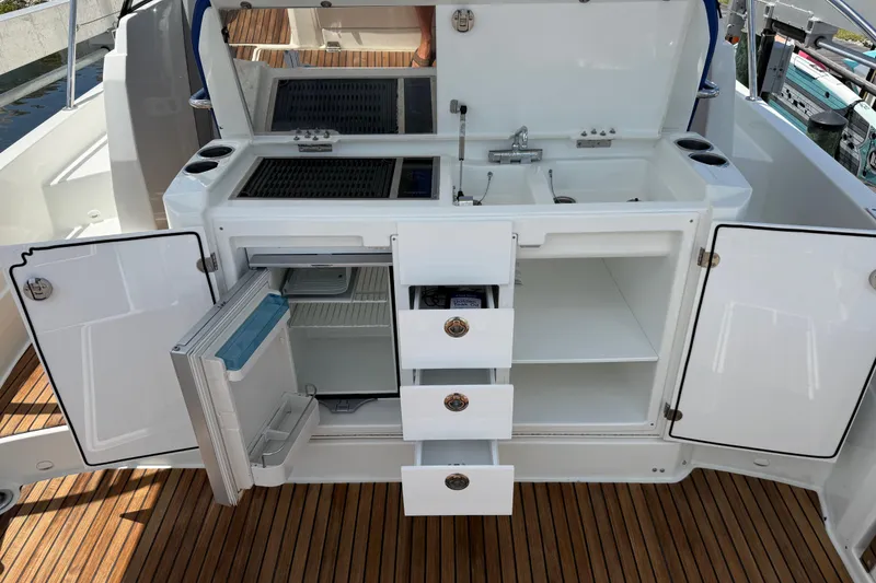 Slide: The Image of 2019 Jeanneau Leader 10.5 boat kitchen with open cabinets and drawers on teak deck. - 39