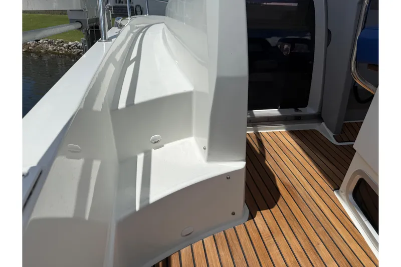 Slide: The Image of 2019 Jeanneau Leader 10.5 boat deck with teak flooring and sleek white design. - 49