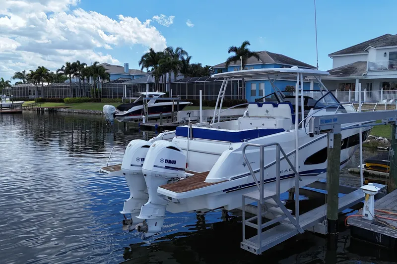 Slide: The Image of 2019 Jeanneau Leader 10.5 boat docked by waterfront homes, featuring twin Yamaha engines. - 5