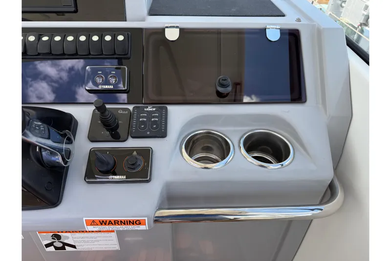 Slide: The Image of Control panel of 2019 Jeanneau Leader 10.5 boat with Yamaha controls and cup holders. - 56