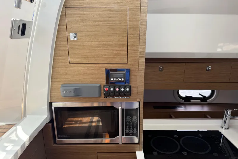 Slide: The Image of 2019 Jeanneau Leader 10.5 yacht interior with microwave, control panel, and stove. - 75