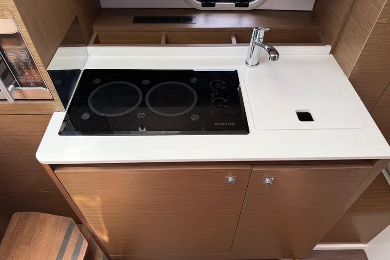 Slide: The Image of Modern kitchen area in a 2019 Jeanneau Leader 10.5 boat, featuring a sleek cooktop and sink. - 80