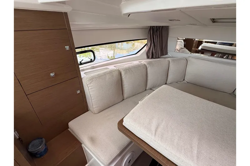 Slide: The Image of Interior of 2019 Jeanneau Leader 10.5 yacht with beige cushions and wooden cabinetry. - 85