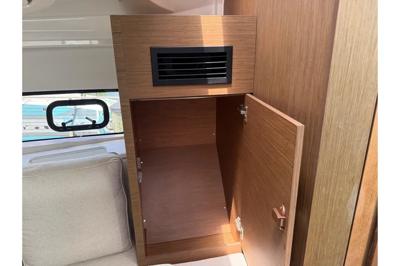 Slide: The Image of Interior of a 2019 Jeanneau Leader 10.5 boat showing a wooden storage cabinet. - 88