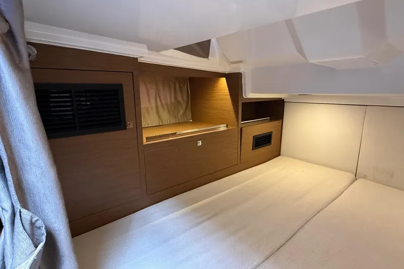 Slide: The Image of Interior cabin of 2019 Jeanneau Leader 10.5 boat, featuring wood paneling and cozy bedding. - 92
