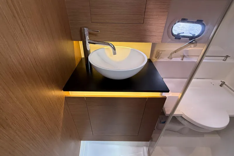 Slide: The Image of Modern bathroom interior of 2019 Jeanneau Leader 10.5 yacht with sleek sink and wooden cabinetry. - 94