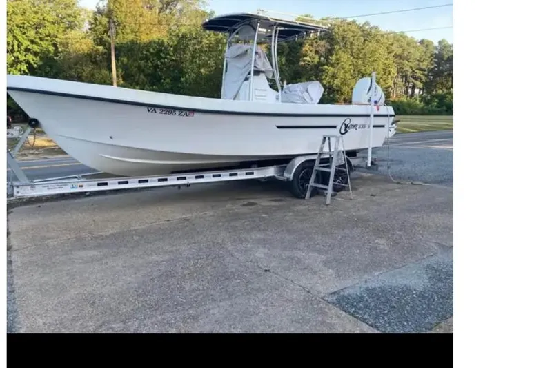 The Image of 2011 C-Hawk 235 Center Console boat on trailer, parked outdoors. - 0