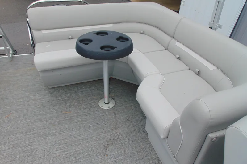 Slide: The Image of 2024 Godfrey Sweetwater 2086 C pontoon boat interior with gray seating and cupholder table. - 18