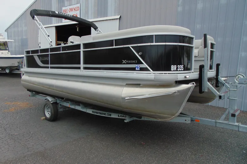 The Image of 2024 Godfrey Sweetwater 2086 C pontoon boat on trailer, parked outside a building. - 2