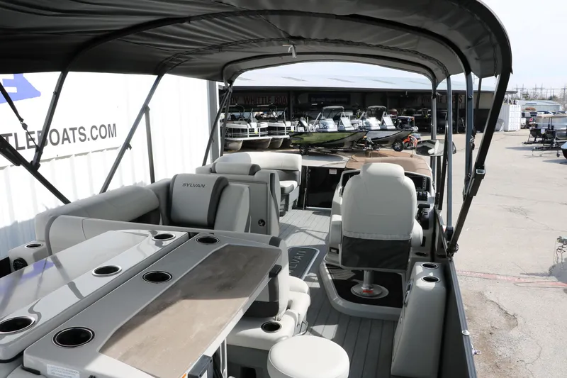 Slide: The Image of 2025 Sylvan MIRAGE X3 DLZ BAR pontoon boat interior with seating and table. - 19