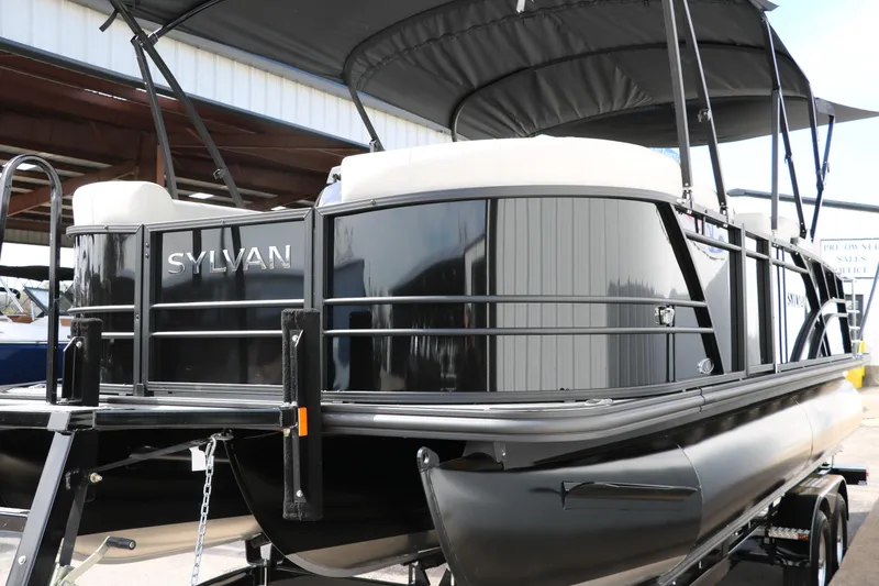 Slide: The Image of 2025 Sylvan MIRAGE X3 DLZ BAR pontoon boat with sleek black exterior and canopy. - 3