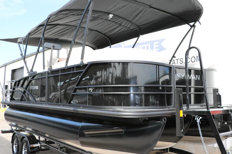 Slide: The Image of 2025 Sylvan MIRAGE X3 DLZ BAR pontoon boat with black canopy and sleek design. - 4