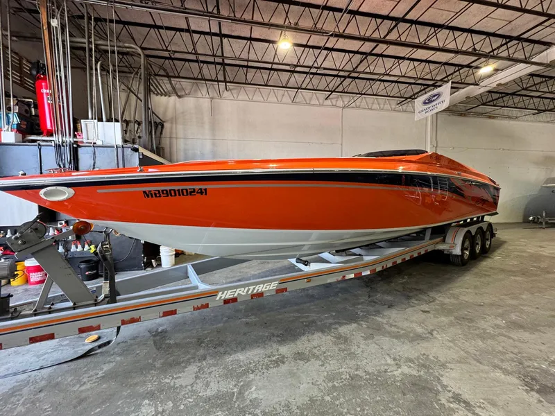 Slide: The Image of 2007 Baja 35 Outlaw speedboat in vibrant orange on a trailer in a warehouse. - 2