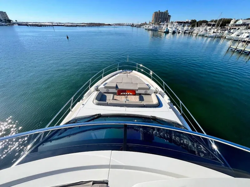 Slide: The Image of 2020 Fairline Squadron 68 yacht on calm waters, marina view in background. - 2