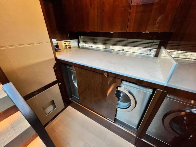 Slide: The Image of Laundry area in 2020 Fairline Squadron 68 yacht with modern appliances and wooden cabinetry. - 30