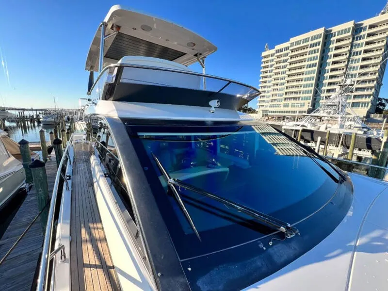 Slide: The Image of 2020 Fairline Squadron 68 yacht docked at marina, modern design, clear blue sky. - 5