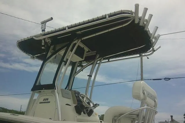 Slide: The Image of 2014 Sea Fox 226 Commander boat with T-top and steering console, under a clear sky. - 12