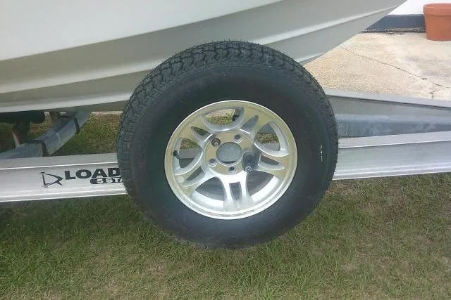 Slide: The Image of Trailer wheel of a 2014 Sea Fox 226 Commander boat on grass. - 6