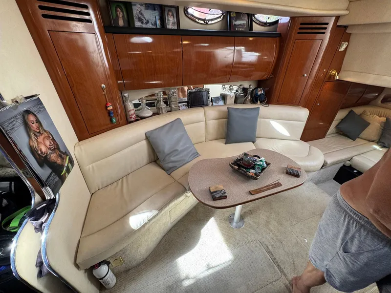 Slide: The Image of Interior of 2002 Sea Ray 360 Sundancer yacht with beige seating and wooden cabinetry. - 23