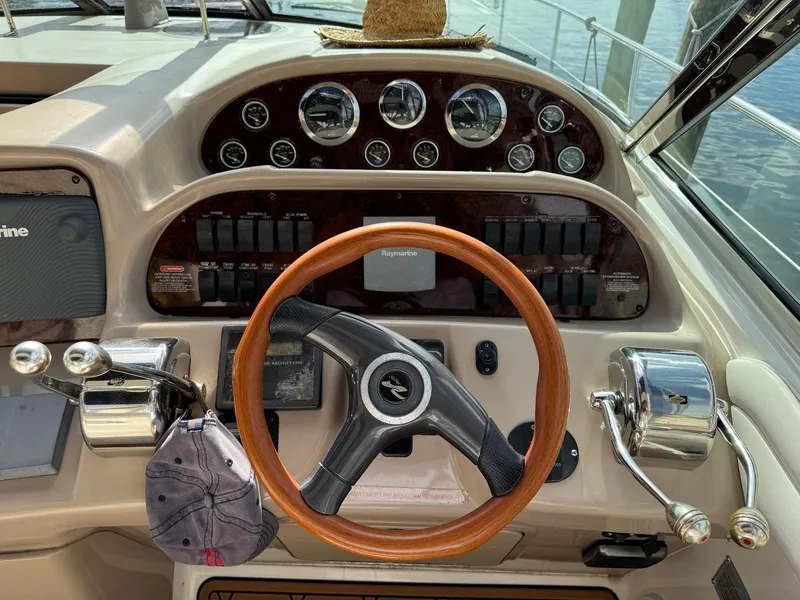 Slide: The Image of 2002 Sea Ray 360 Sundancer helm with wood steering wheel and control panel. - 18