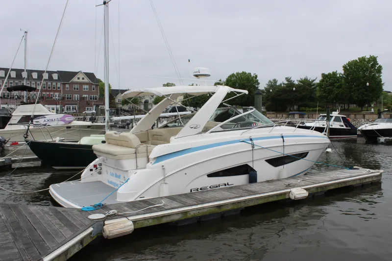 The Image of 2018 Regal 33 Express boat docked at marina, overcast sky. - 1