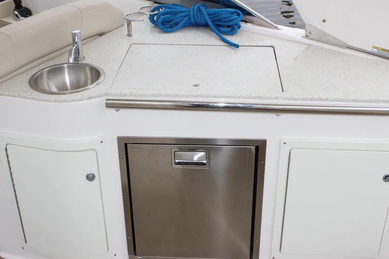 Slide: The Image of 2018 Regal 33 Express boat kitchenette with sink, countertop, and storage. - 13