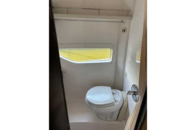 Slide: The Image of 2018 Regal 33 Express boat bathroom with toilet and window. - 24
