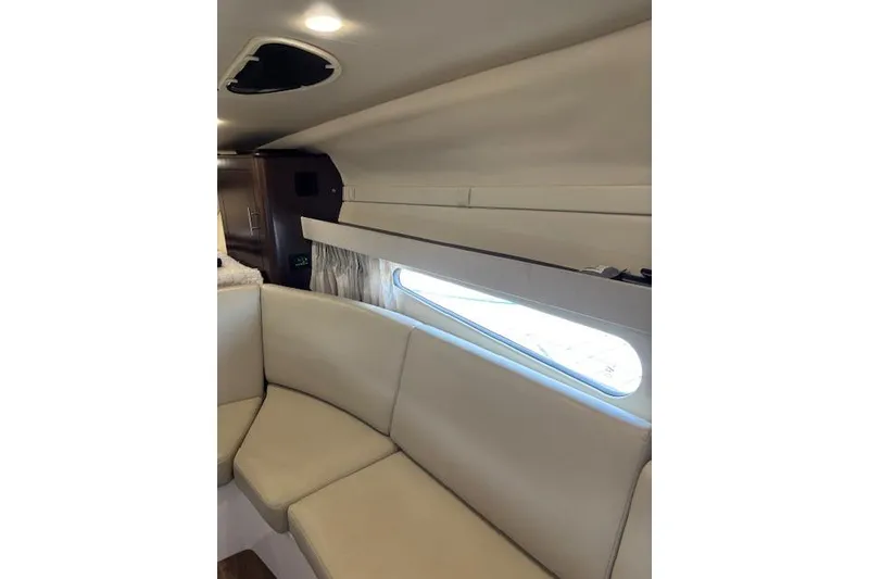 Slide: The Image of Interior of 2018 Regal 33 Express boat with beige seating and window. - 29