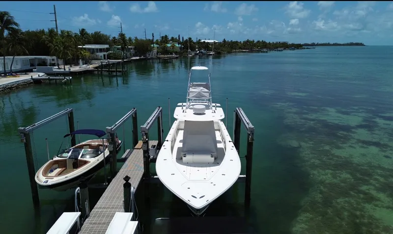 Slide: The Image of 2014 SeaVee 390B Center Console docked in a serene coastal setting. - 2
