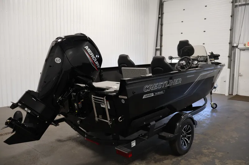 Slide: The Image of 2027 Crestliner 1650 HAWK SC boat with Mercury engine in a garage setting. - 9