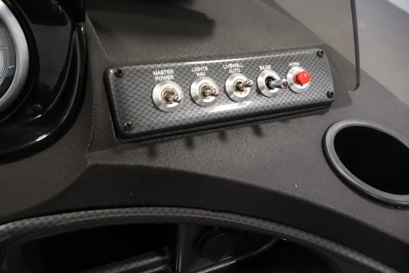 Slide: The Image of Control panel of 2027 Crestliner 1650 Hawk SC boat with switches and cup holder. - 28