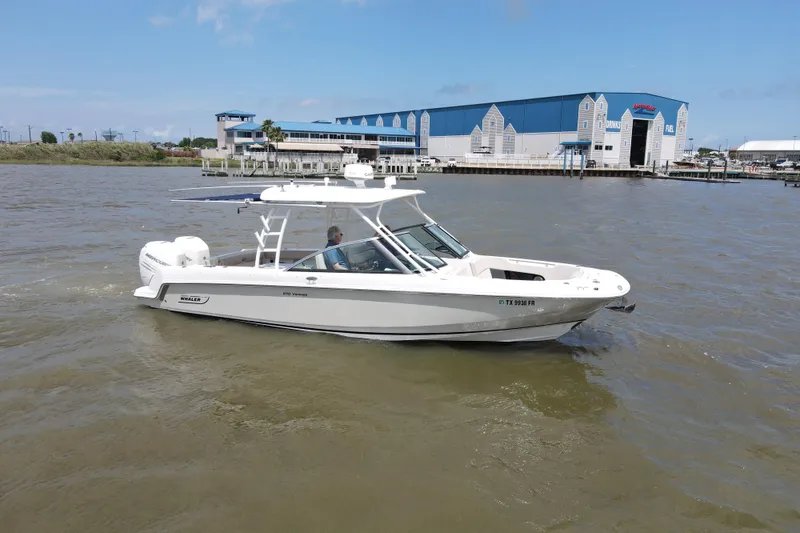 Slide: The Image of 2017 Boston Whaler 270 Vantage boat cruising near marina under clear blue sky. - 10