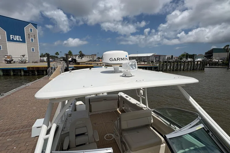Slide: The Image of 2017 Boston Whaler 270 Vantage docked near fuel station under cloudy sky. - 24
