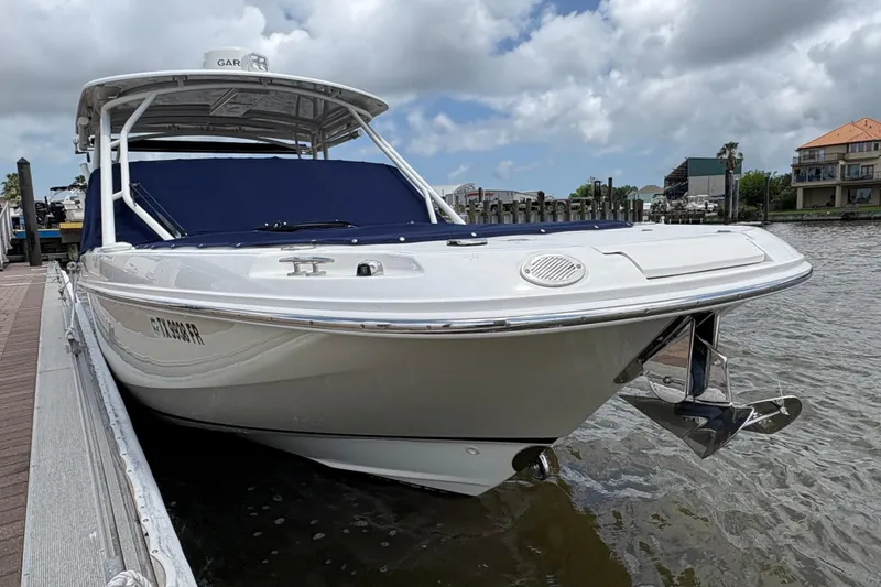 Slide: The Image of 2017 Boston Whaler 270 Vantage boat docked by the waterfront under cloudy skies. - 39