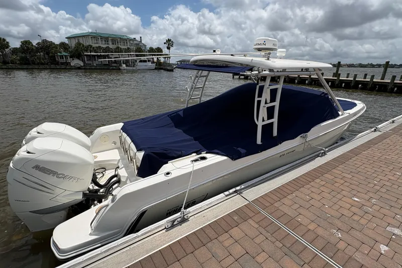 Slide: The Image of 2017 Boston Whaler 270 Vantage docked with twin Mercury engines, covered in blue tarp. - 42