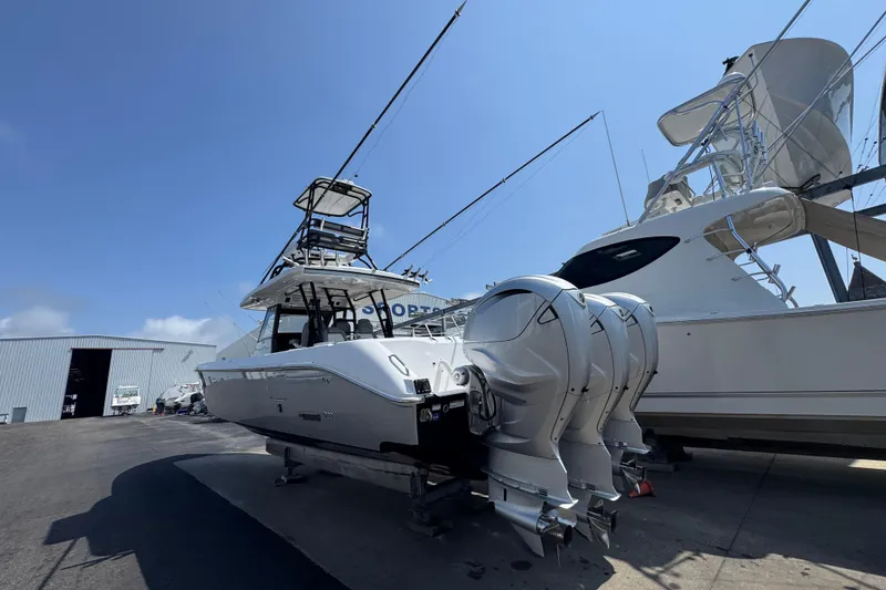 Slide: The Image of 2022 Everglades 395 Center Console boat with triple engines in a marina setting. - 10