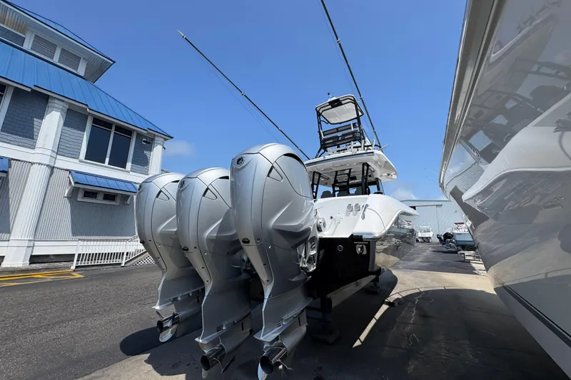 Slide: The Image of 2022 Everglades 395 Center Console boat with triple outboard engines at a marina. - 12