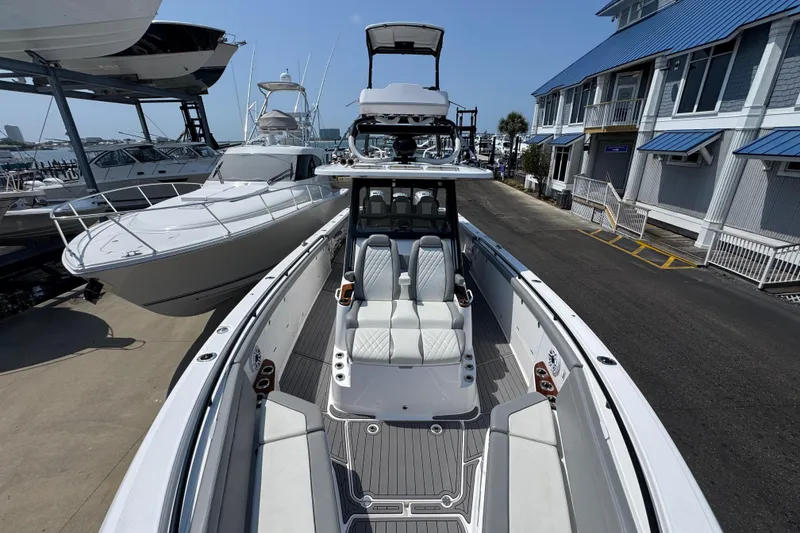 Slide: The Image of 2022 Everglades 395 Center Console boat docked at marina, showcasing sleek design and seating. - 17