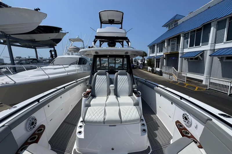 Slide: The Image of 2022 Everglades 395 Center Console boat docked at marina, showcasing luxury seating and design. - 18