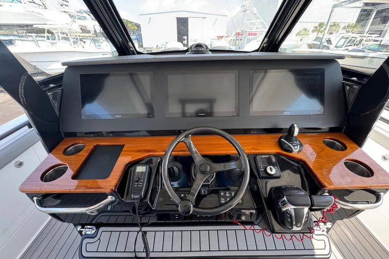 Slide: The Image of 2022 Everglades 395 Center Console helm with modern controls and wooden dashboard. - 28